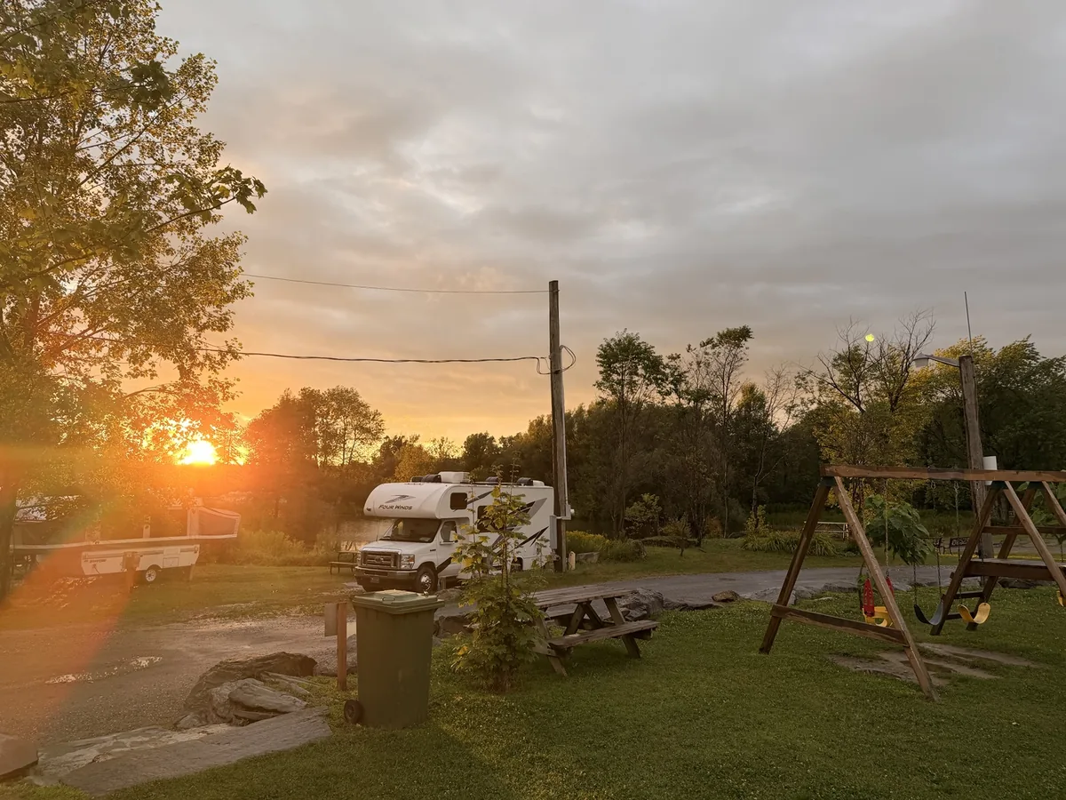 Balançoires et table de pique-nique au parc, au coucher du soleil