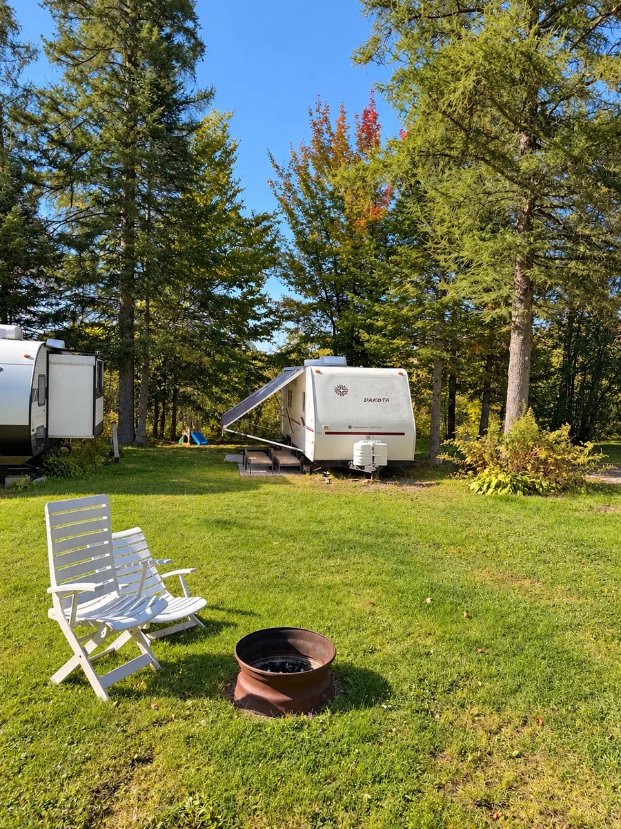 Terrain 31 avec pelouse, grands arbres et espace pour un foyer